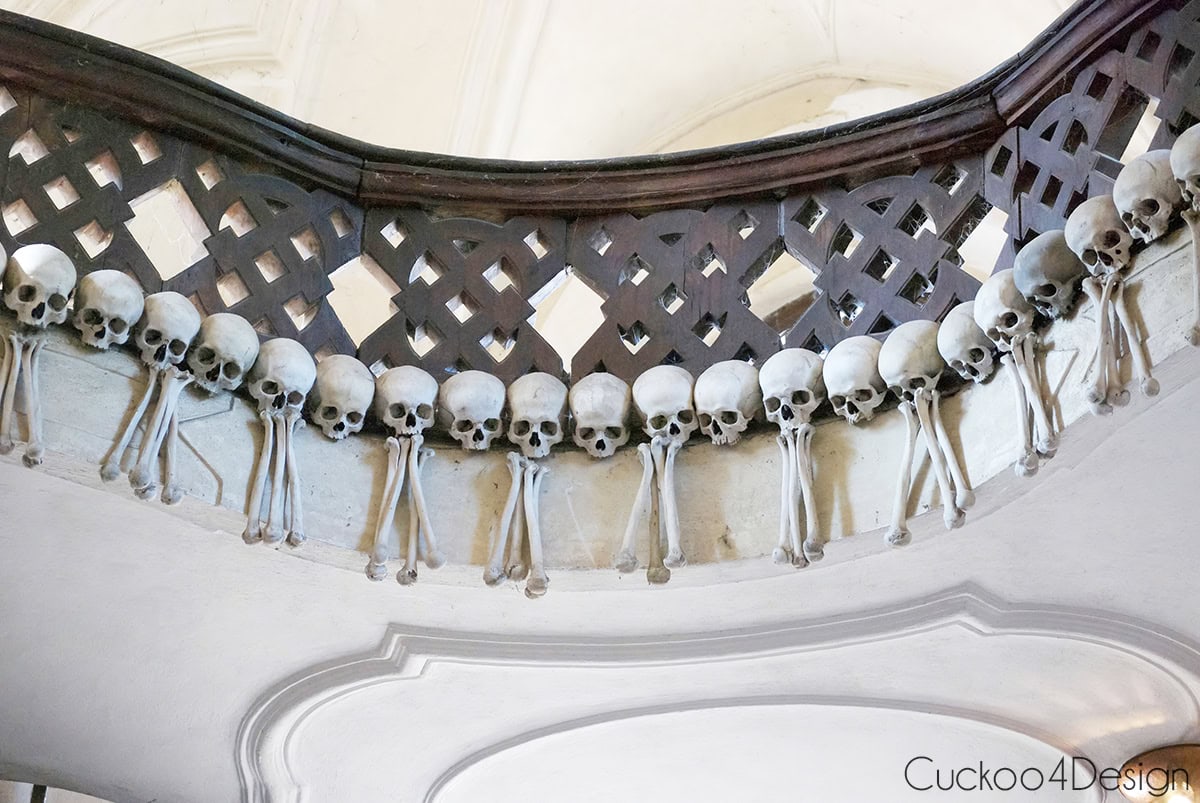 Row of skulls hanging along the edge of a balcony inside the Sedlec Ossuary